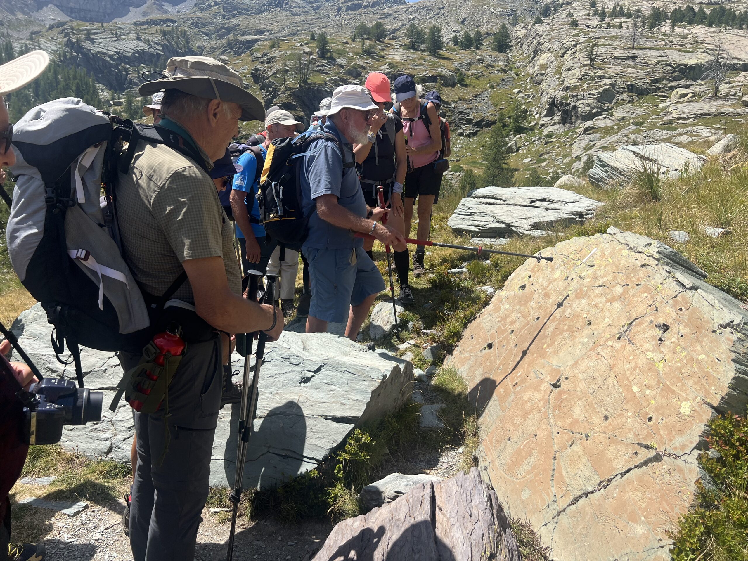 Randonneurs devant une roche gravée à Fontanalbe