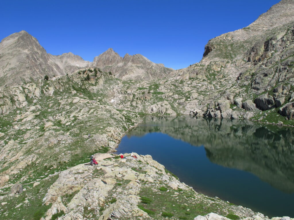 Randonneurs devant un lac d’altitude dans le Mercantour