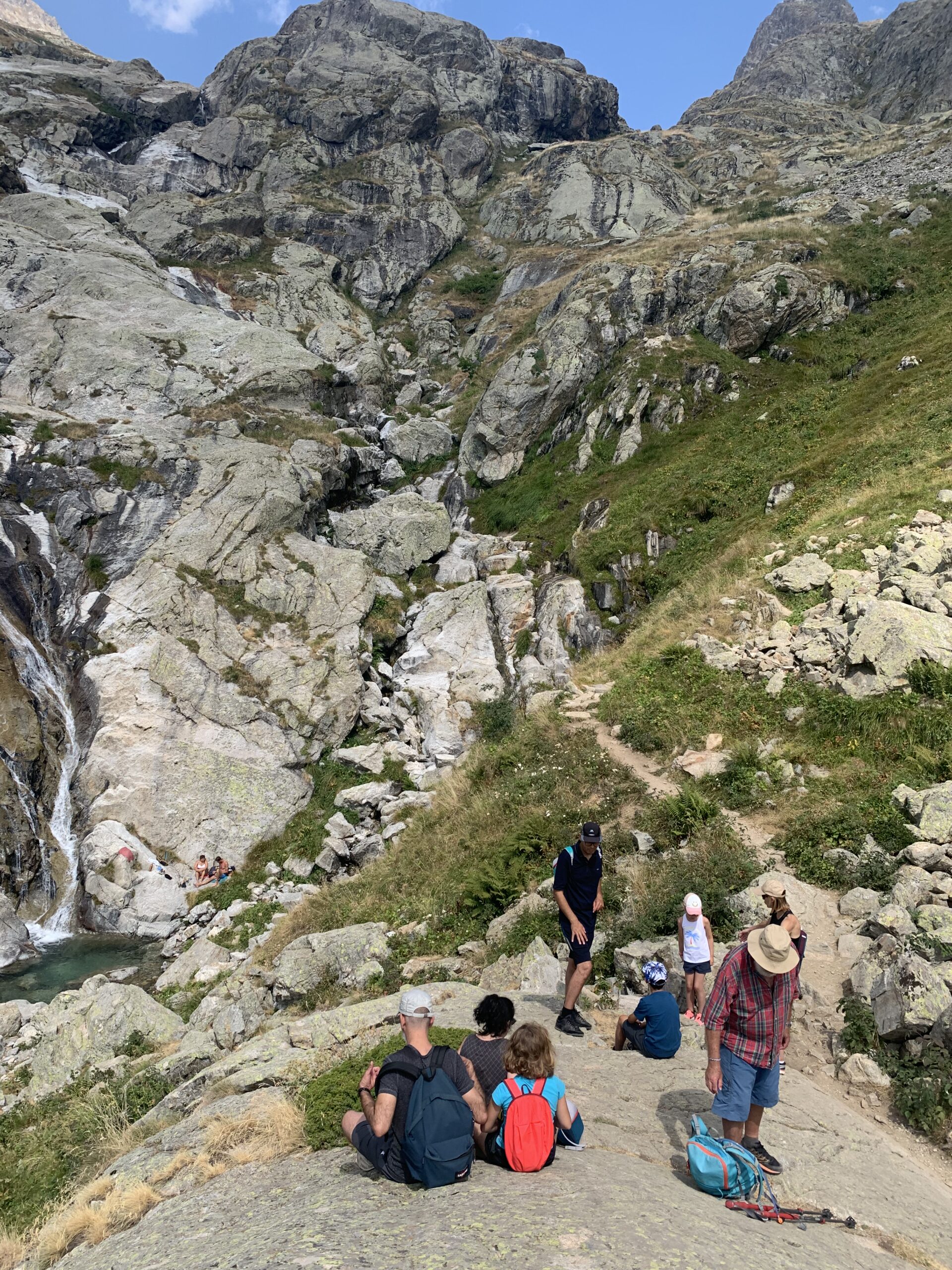 Enfants et adultes en randonnée près d’une cascade